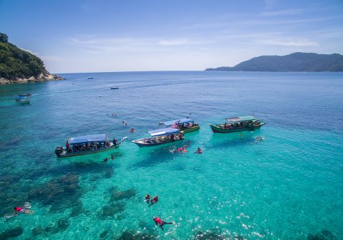 snorkeling group in clear water at perhentian island, terengganu malaysia